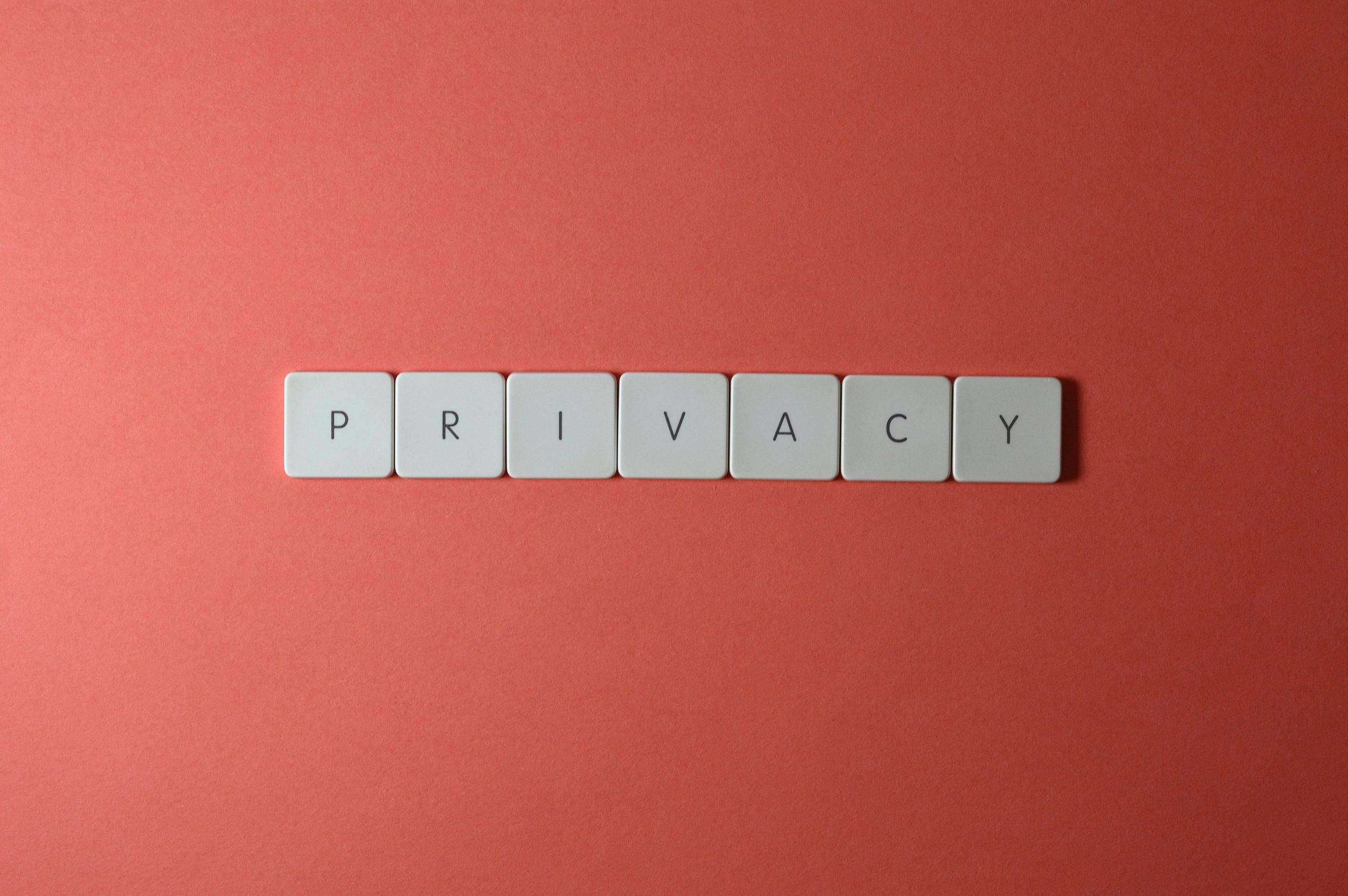 Close-up of letter tiles spelling PRIVACY on a red background, symbolizing data protection.
