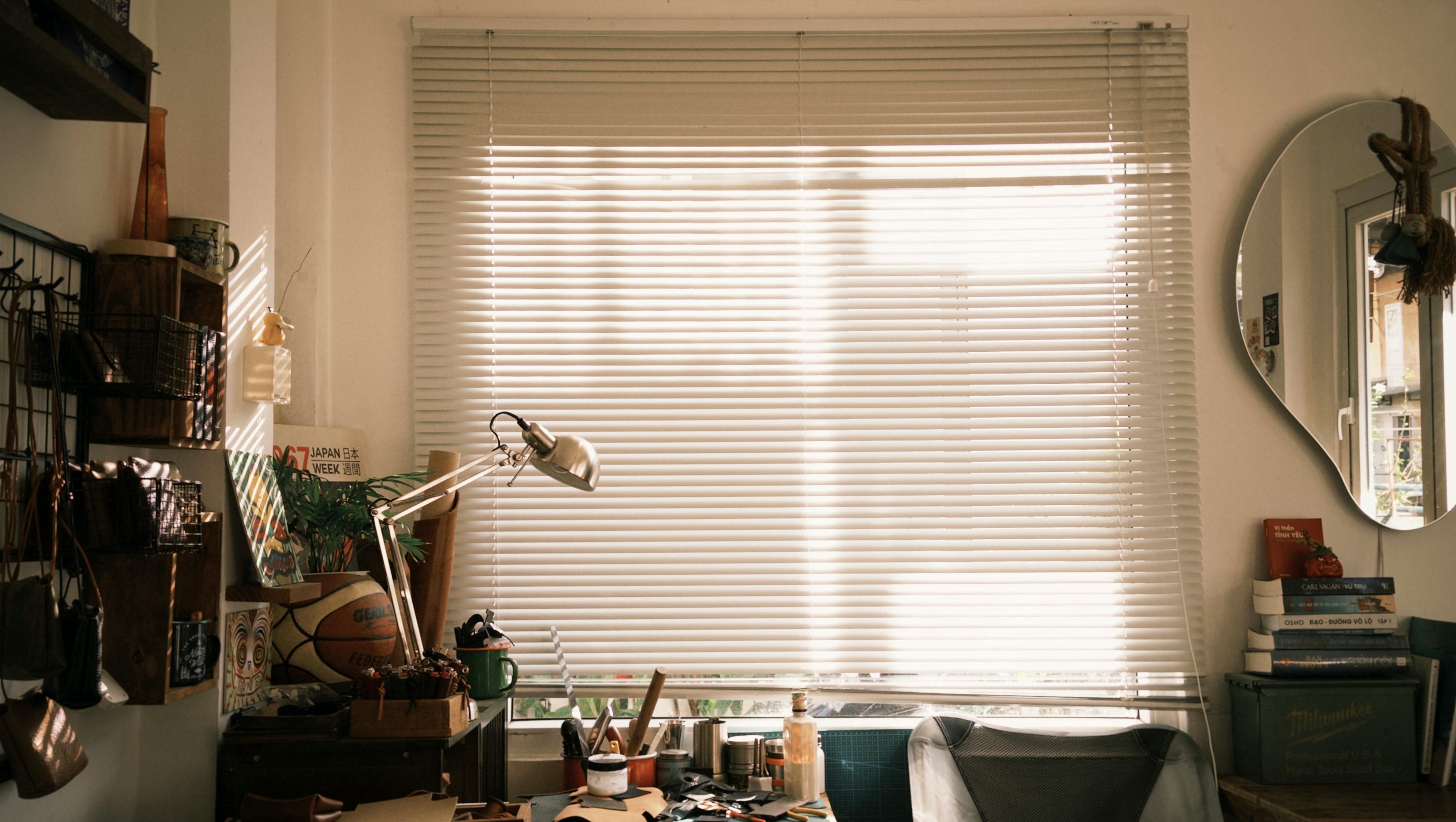A warm, inviting home workspace with natural light filtering through blinds, creating a cozy atmosphere.