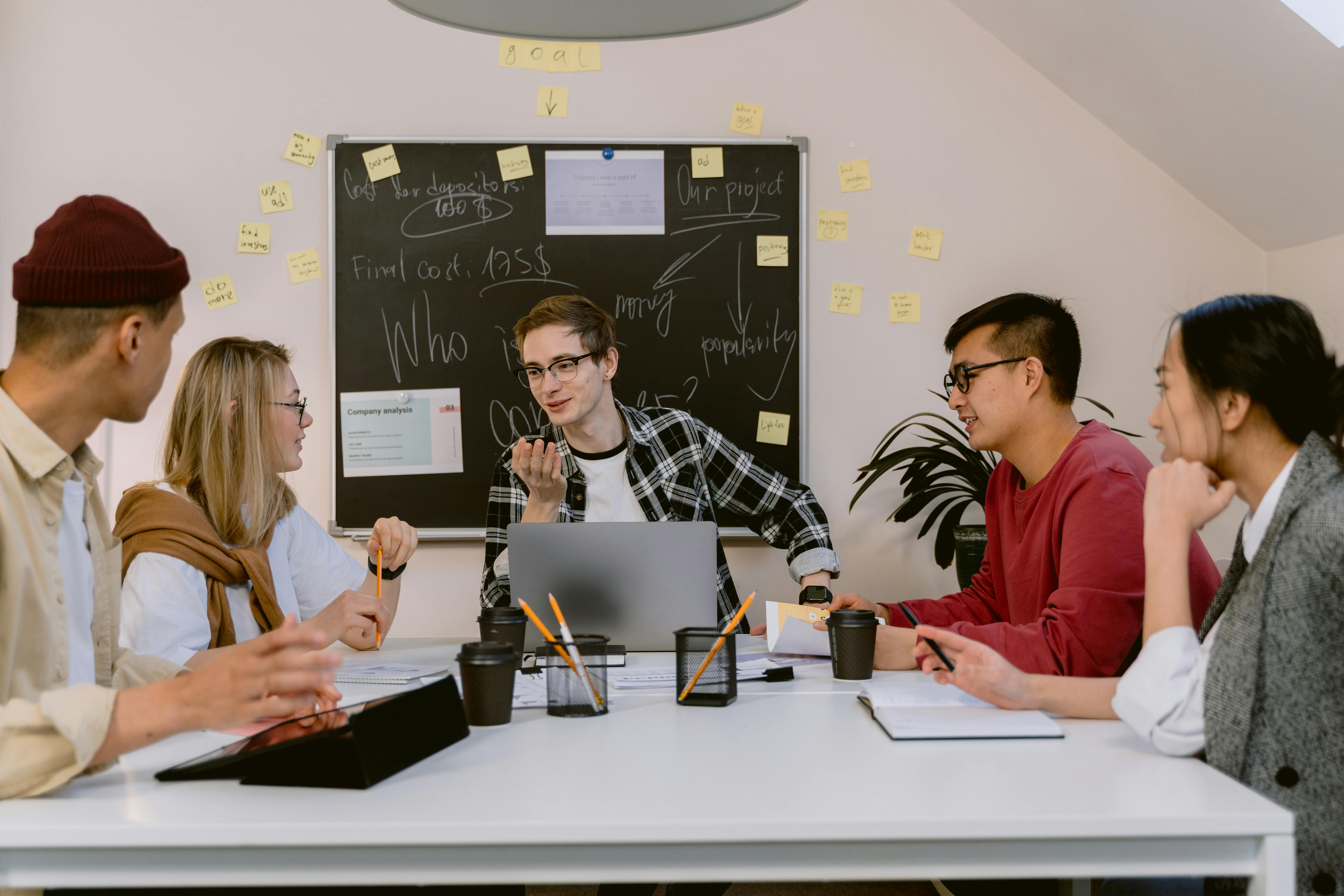 A group of young professionals collaborating on a project in a modern office setting.