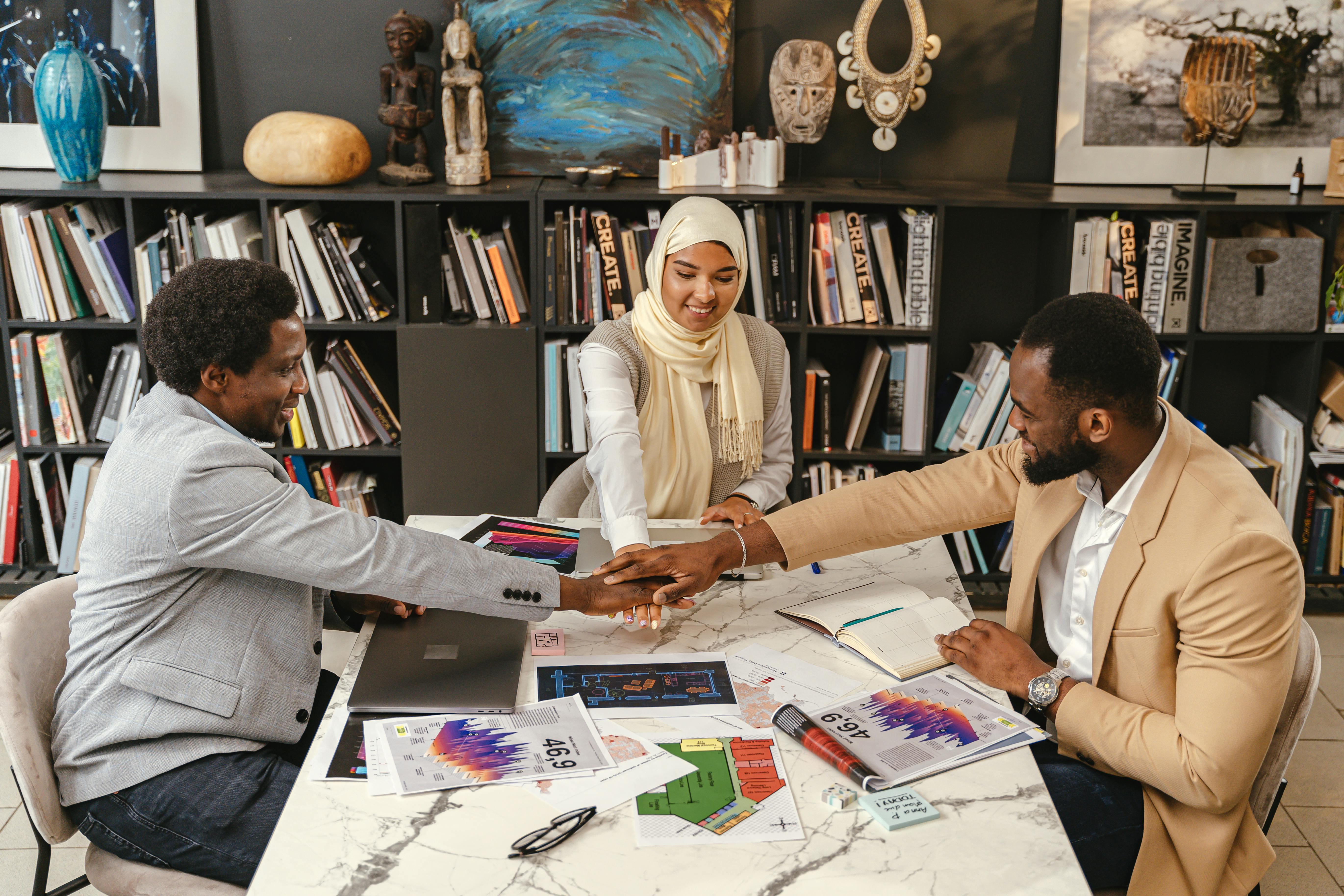 Three professionals in an office setting engage in team collaboration, fostering innovation and cooperation.